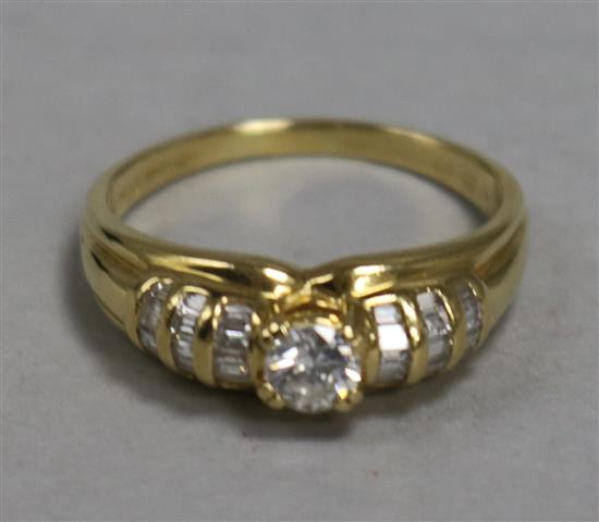 An 18ct gold and diamond ring, the central stone approx 0.25ct, flanked by baguette-set shoulders, 4.1gr gross.
